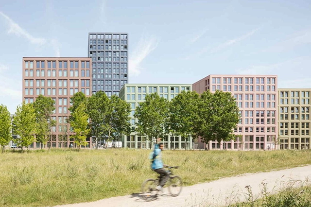 A new mid-rise development in Strasbourg with a park in front.