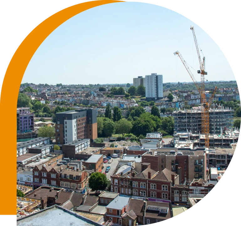 This image is taken from a nearby tall building and is looking out towards East Street in the foreground and Windmill Hill in the background. The image shows a crane working on a construction site.