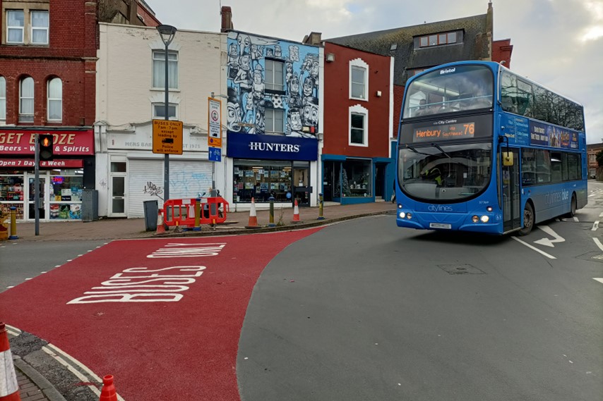 A double decker bus turning onto East Street. The road is marked to say busses only.