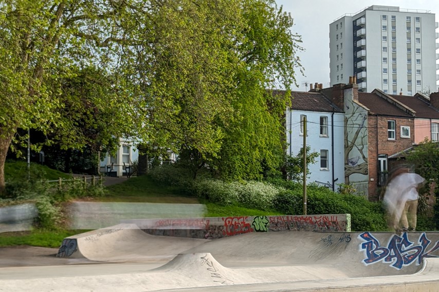 Skaters using the new equipment in Victoria Park. Trees and houses in the background.