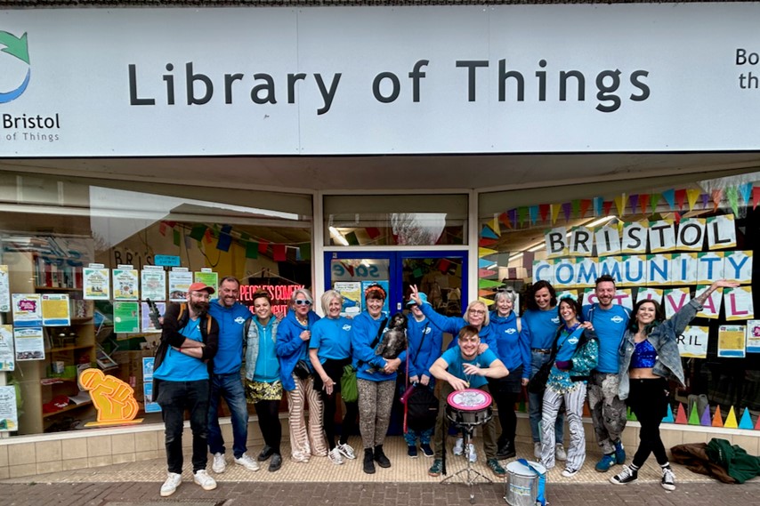 A group of people wearing blue tshirts stand in front of the Library of Things on East Street in Bristol.