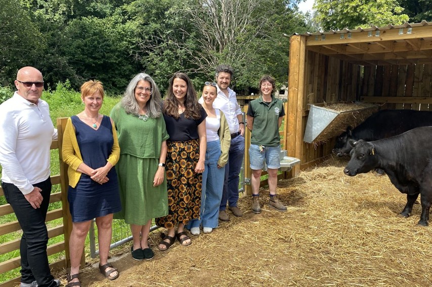 People from Dandara and Windmill Hill city Farm stand next to a newly constructed cow shed