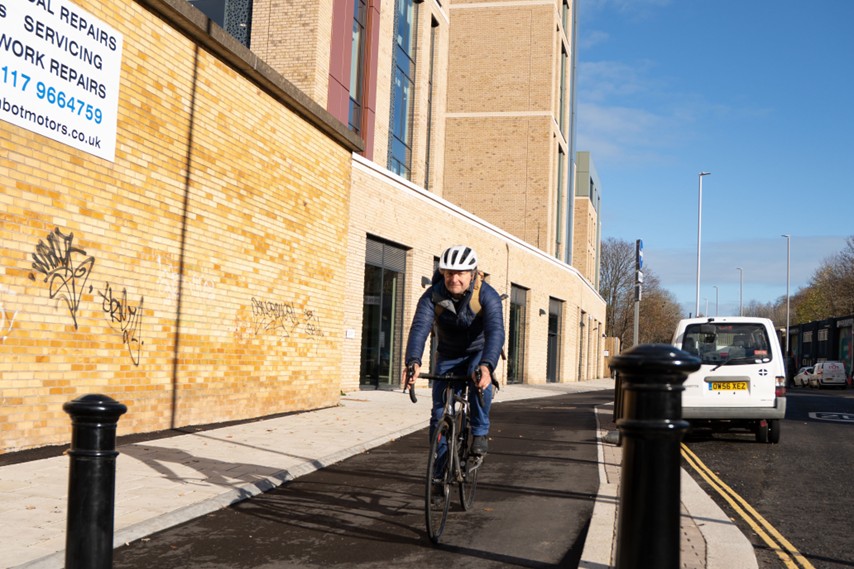Someone on a bike travels along a newly built cycle path on Whitehouse Lane.